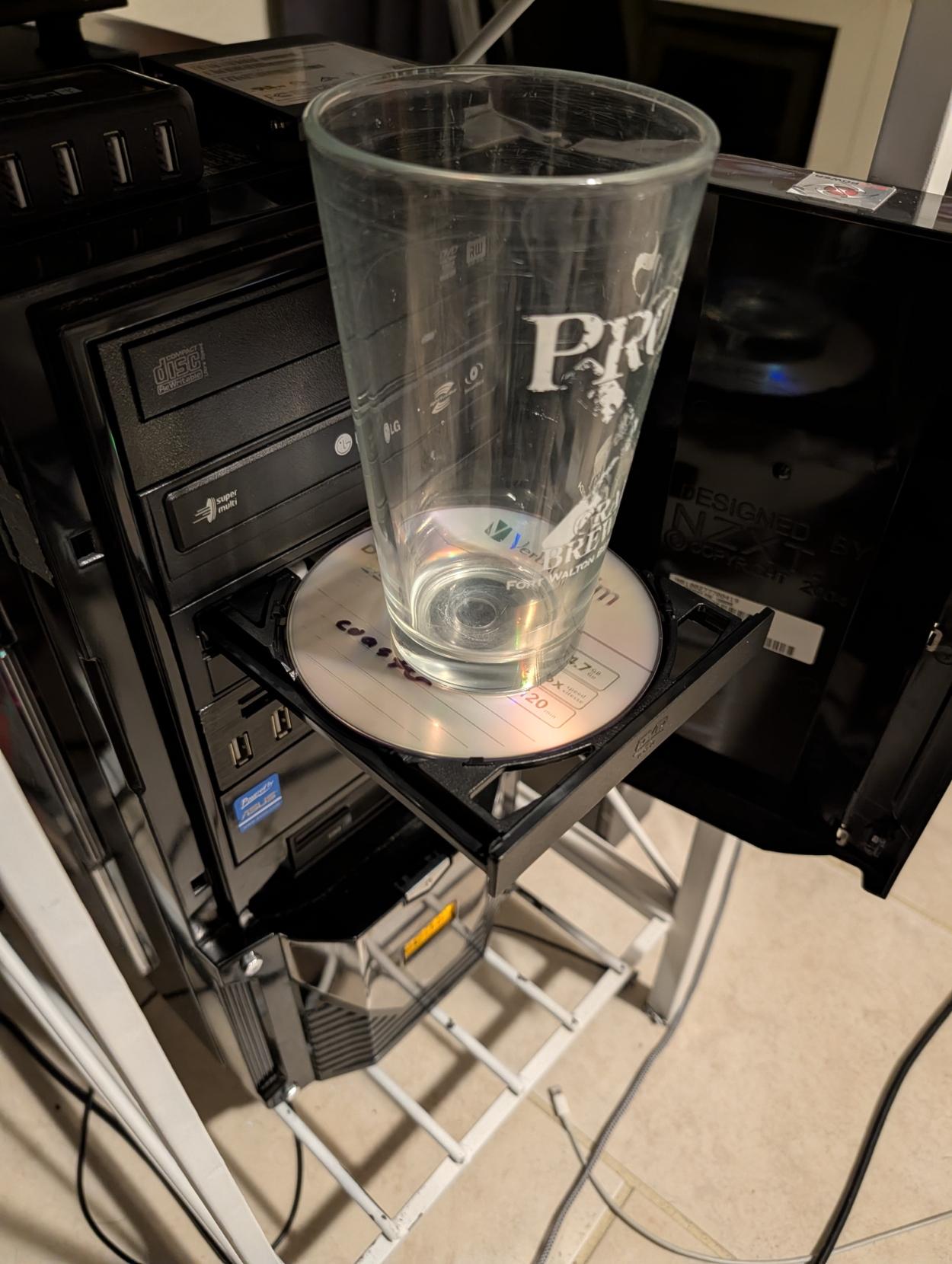 a glass sitting on top of my coaster dvd sitting on my computer's disc drive